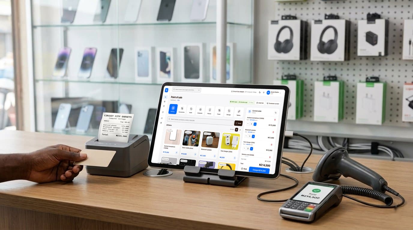 A phone and gadget shop counter with finpo: a tablet on a stand showing finpo's selling screen, a receipt printer with the receipt, a card machine that says paid, and a barcode scanner.
