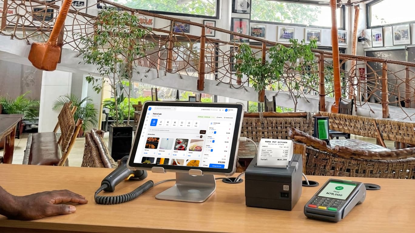 A restaurant counter with finpo: a tablet on a stand showing finpo's selling screen, a receipt printer with the receipt, a card machine that says paid, and a barcode scanner.